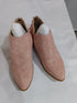 Pink faux-suede booties photographed from above