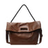 Brown foldover hobo bag showing cutout handle on white background