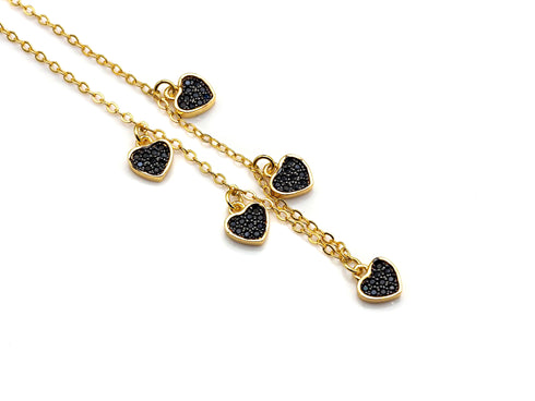 Close-up of the necklace black heart charms and gold-tone chain links