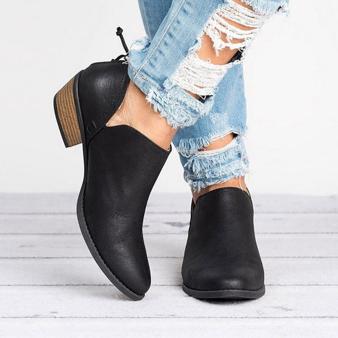 Black ankle booties worn with distressed jeans