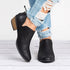 Black ankle booties worn with distressed jeans