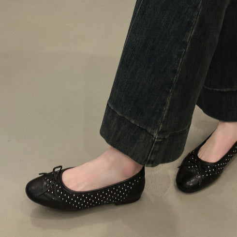 Black perforated ballet flats worn with dark cropped jeans