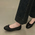 Black perforated ballet flats worn with dark cropped jeans