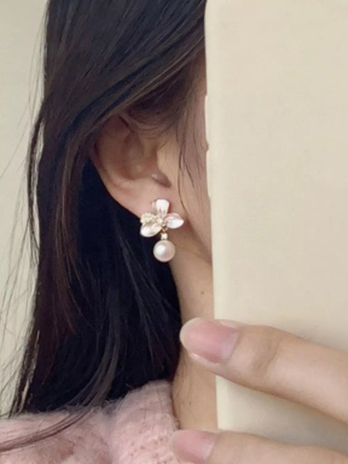 Side view of a flower pearl-drop earring worn on a model