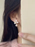 Side view of a flower pearl-drop earring worn on a model
