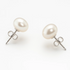 Angled close-up of white pearl studs and butterfly closures