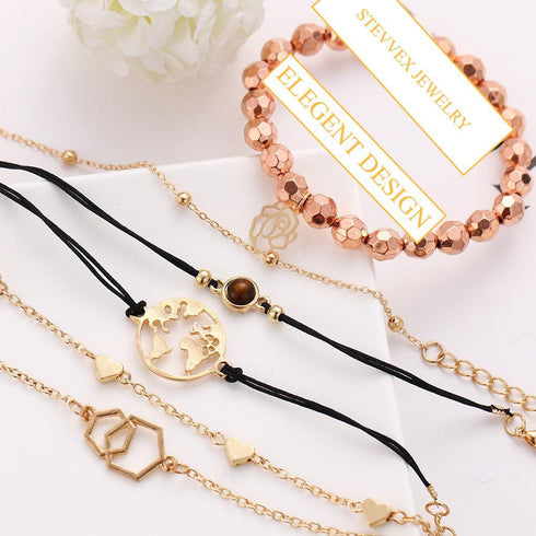 Rose-tone bracelet stack arranged with black cords and geometric charms