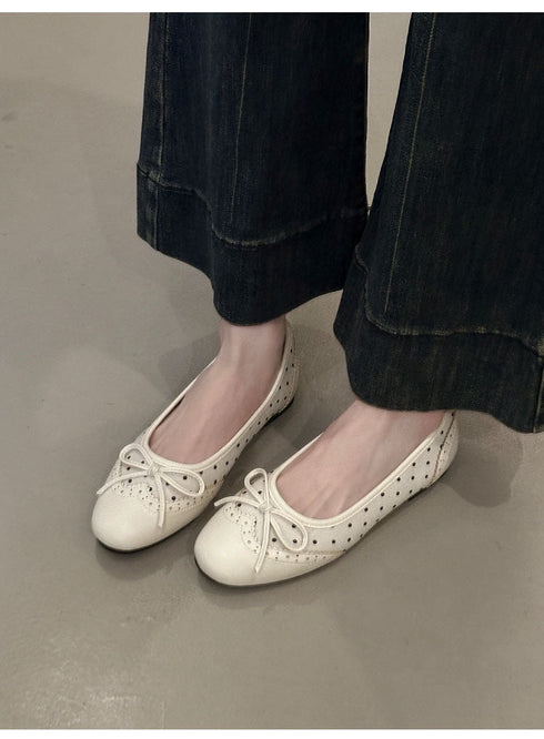 Beige bow ballet flats worn with wide-leg dark denim