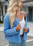 Blue chunky cardigan worn open over a white top and jeans