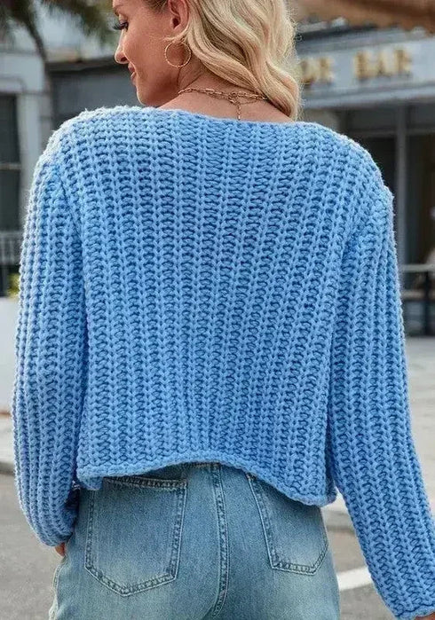 Back view of blue cropped chunky knit cardigan with ribbed hem