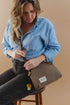Front view of seated model wearing the Hopper canvas crossbody