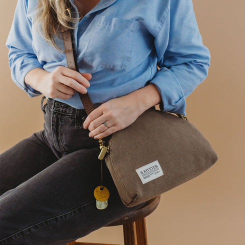 Hopper canvas crossbody worn with a blue shirt and dark denim