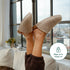 Beige Fulton House Shoes worn with raised feet, showing rounded toes and open backs
