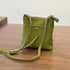 Green RockCow leather phone crossbody at an angle with its shoulder strap
