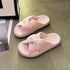 Pink ribbed bow slide slippers displayed on a chair