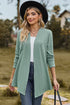 Light green textured cardigan worn open with a hat