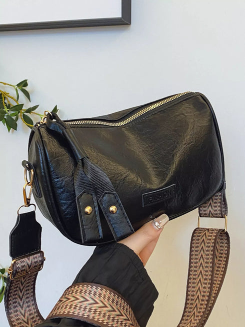 Black retro crossbody bag held in a hand