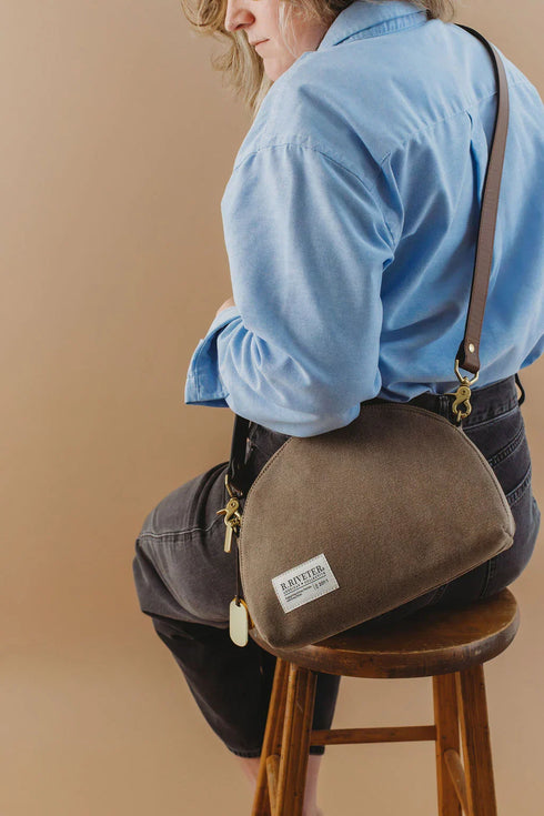 Rear side view of Hopper bag worn crossbody with a blue shirt