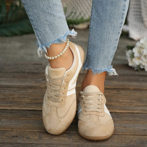 Front view of beige retro sneakers worn with jeans
