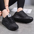 Black platform sneakers showing round toes and side profile