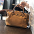 Brown RockCow TS923 handbag held by the handles with an Alice monogram example