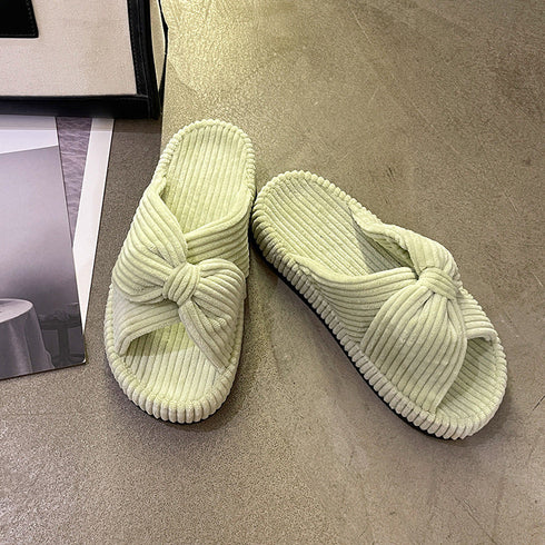Green ribbed fleece bow slippers displayed as a pair