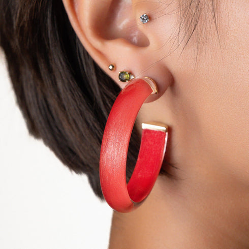 Close-up of red Illusion hoop earring worn on the ear