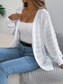 White crochet-knit cardigan, seated view with the open front visible