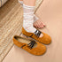 Brown lace-up flats shown on and beside the wearer’s feet