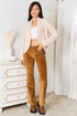Full-length outfit view of cream cardigan with brown trousers