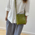 Green RockCow mini crossbody worn with a white shirt for scale