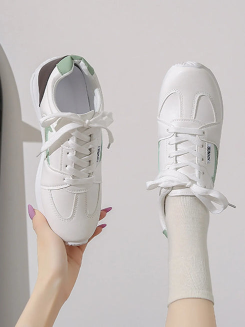 Top view of white green-accent lace-up sneakers