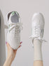 Top view of white green-accent lace-up sneakers
