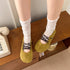 Green lace-up flats worn with white socks, angled view