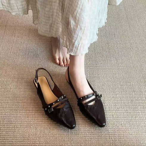 Dark textured slingback flats worn with a cream skirt, viewed from above