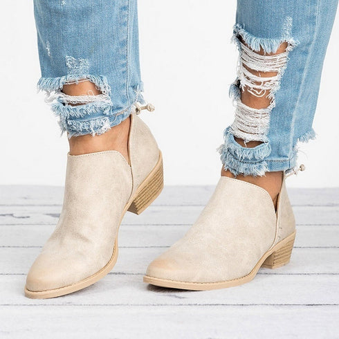 Beige ankle booties worn with cuffed blue jeans