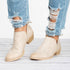 Beige ankle booties worn with cuffed blue jeans