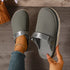 Top view of gray clogs with one shoe worn and the other held