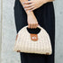 Straw-color Stella purse carried by the top handle
