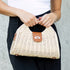Front view of pale straw Stella bag with contrast clasp tab