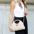 Straw-color woven purse worn with adjustable crossbody strap