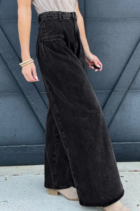 Side-angle view of black high-rise jeans showing the full wide-leg silhouette
