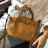 Brown RockCow TS923 leather handbag held on a seated model’s lap