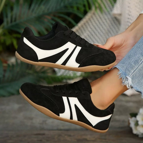 Side profile of black retro sneakers with tan-colored soles