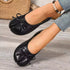 Angled view of black bow-detail flats showing split toes