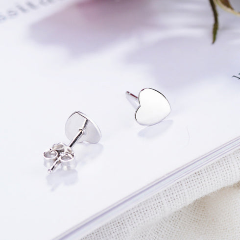 Sterling silver heart stud earrings showing one heart face and one post with butterfly back