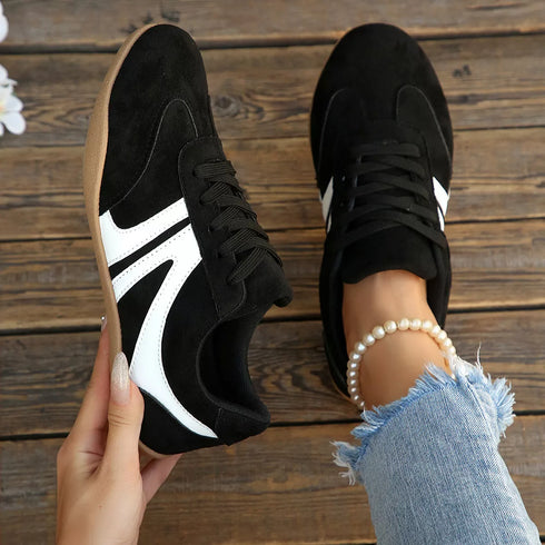 Top view of black sneakers with white side panels