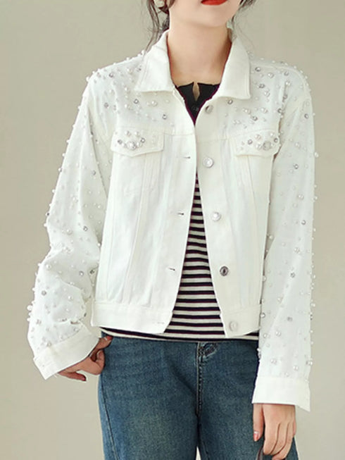 White pearl-style embellished denim jacket worn over a striped top