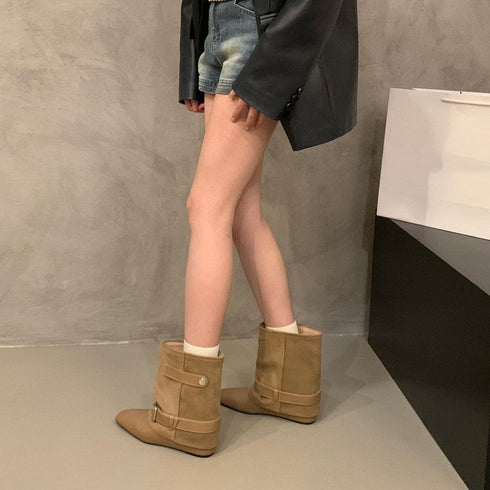 Khaki pointed-toe boots worn with shorts, side view