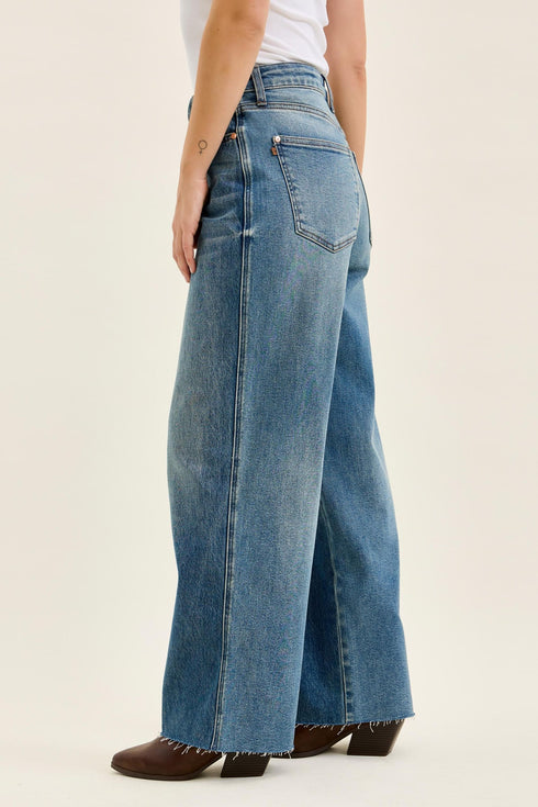 Side view of vintage indigo Wilhelmina baggy jeans and their wide-leg shape